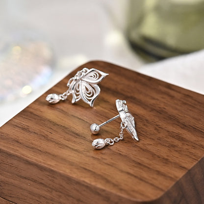 Sterling silver butterfly tassel earrings shown from side with dangling teardrop charm