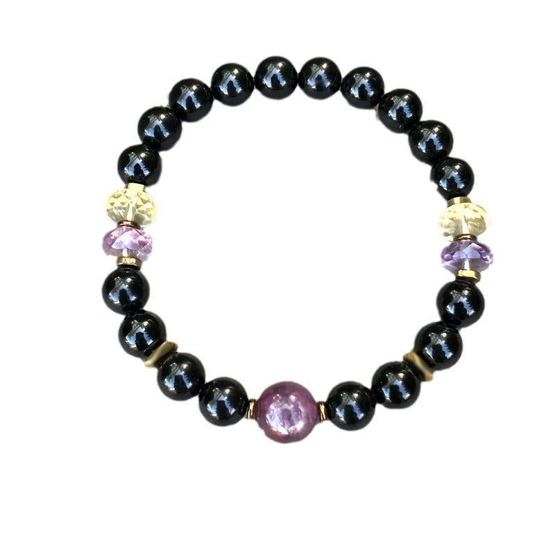 Black round bead bracelet with a purple center gemstone and small crystal-like spacers