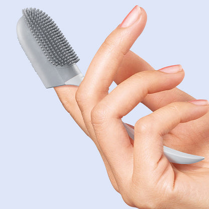 Silicone finger toothbrush with gray bristle pad on finger