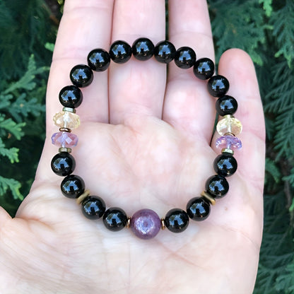 Black bead bracelet with purple center cabochon and gold-and-amethyst side accents